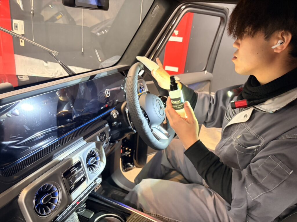 メルセデスAMG G63のハンドルにクロスで液を塗るスタッフ