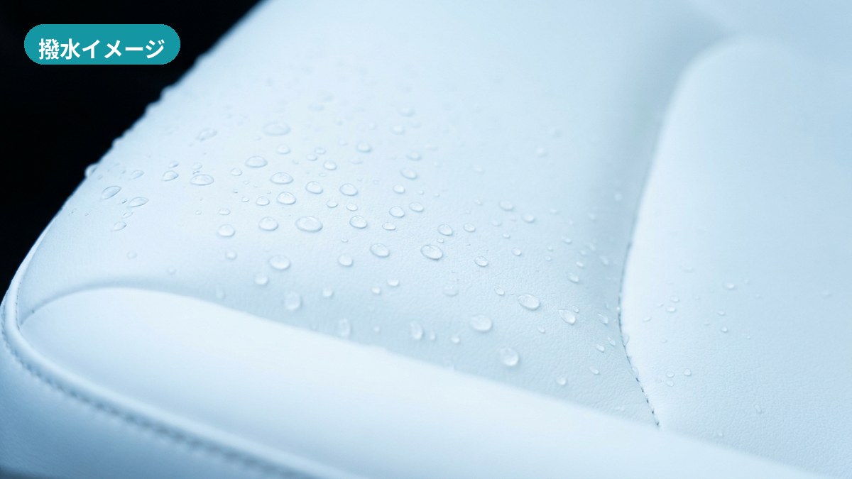 水性シートコーティング施工後、白いレザー表面で水滴が玉状に弾かれる様子（撥水・防汚イメージ）