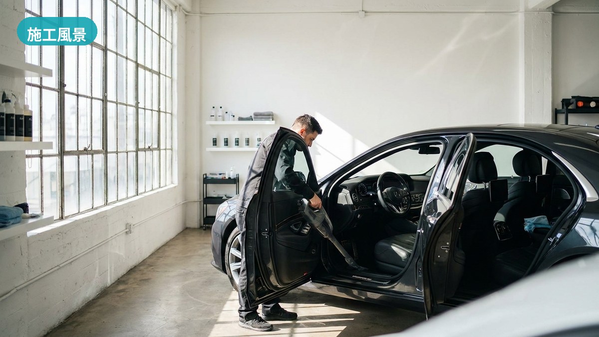明るい作業場で車内シートの黄砂・花粉・潮の微粒子を丁寧に除去するカーディティリング沖縄のスタッフ（南城市・施工風景）