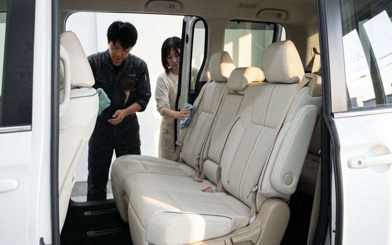 洗浄を終えたミニバン3列目シートへ、Starexの水性シートコーティングを丁寧に施工している様子