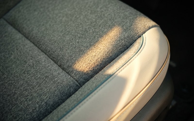 洗浄を終えた運転席シートへ、ART RISE アートライズが水性シートコーティングをムラなく施工している場面