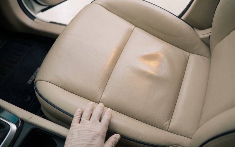 洗浄を終えた本革シートへ、Car Detailing BECSELが水性シートコーティングを均一に塗り込んでいる施工風景