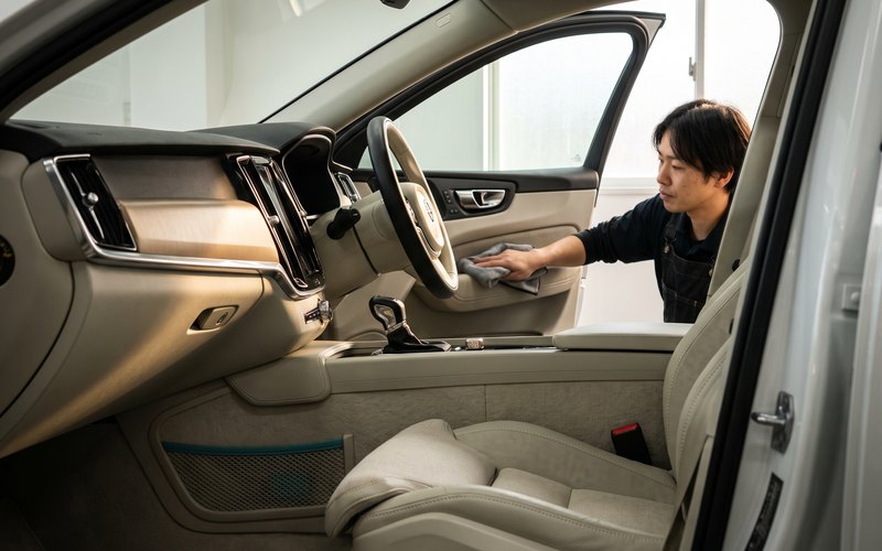 乗り降りの多い運転席シートとドア内側を専用機材で洗浄している車内クリーニングの作業