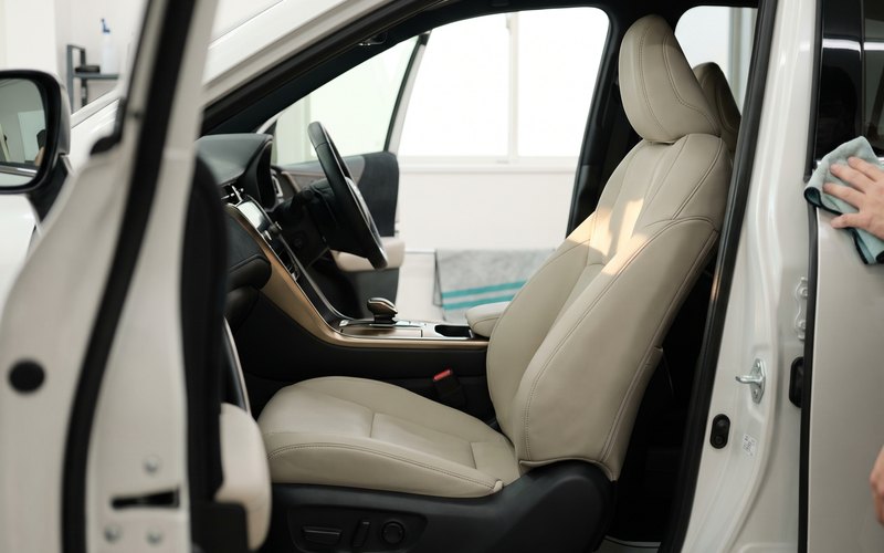 洗浄を終えた軽自動車の本革シートへ水性シートコーティングを施す、長久手市ニシムラの施工風景