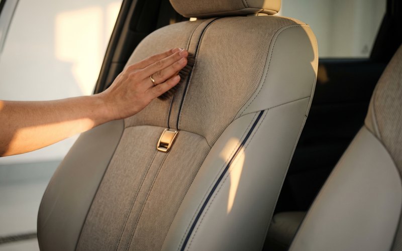 G.R.A AUTO WORKSの作業風景。ミニバンの3列目シートを起こし、格納部の谷間と座面の合わせ目を専用機材で洗浄しているところ