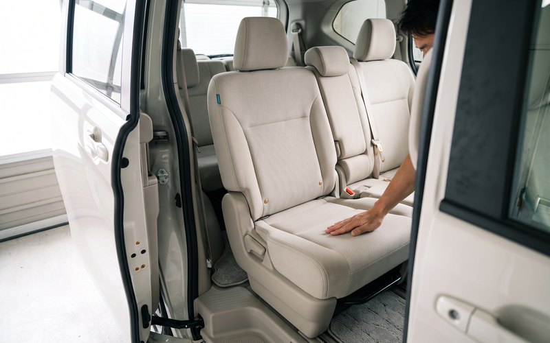 洗浄を終えた2列目シートに、G.R.A AUTO WORKSが水性シートコーティングを均一に施工している場面