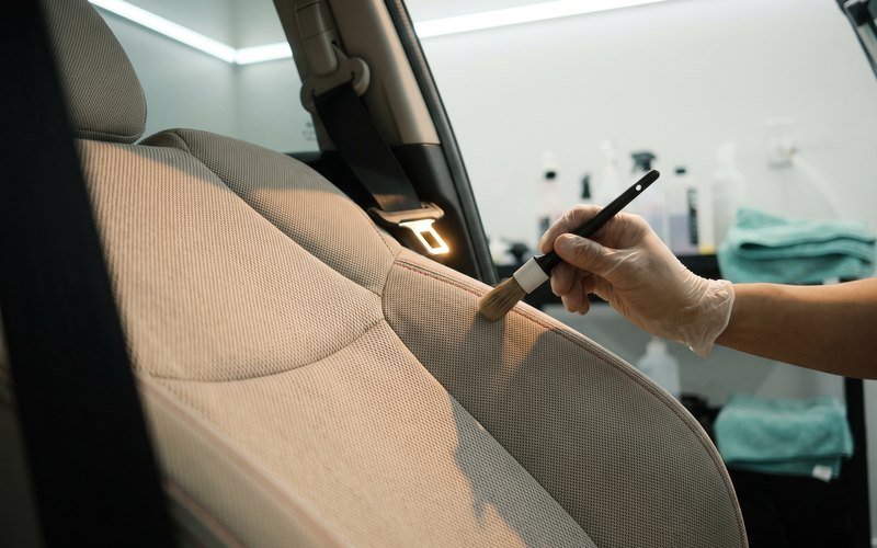 堺市の株式会社ケイゾーインターナショナルで、軽自動車のファブリックシート全体を専用機材で洗浄している作業の様子