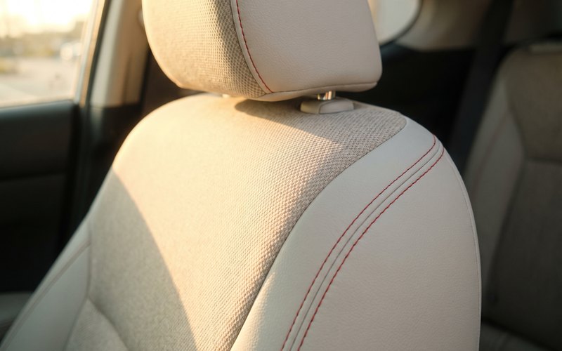 洗浄を終えた中古車のヘッドレストとアームレストへ、株式会社KHエンジニアリングが水性シートコーティングを施工している場面