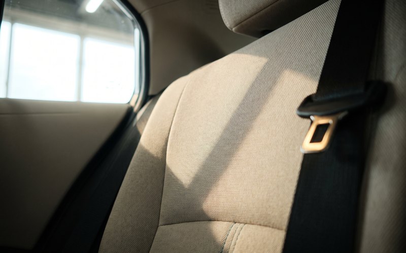 洗浄後の後席座面とベルト周辺に、水性シートコーティングを重ね塗りせず均一に施工しているカーウォッシュラボしらたの工程写真