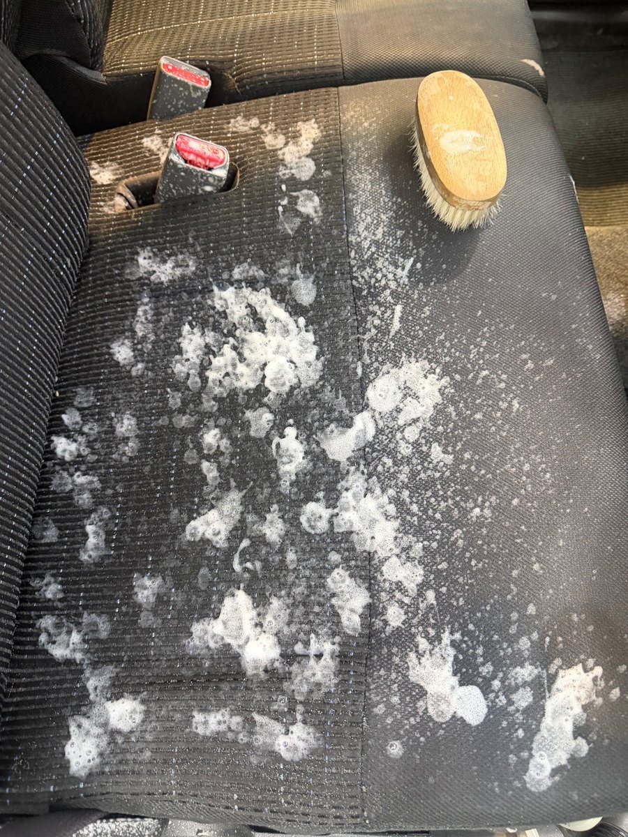 ムーヴカスタムの布シートの座面に洗浄剤の泡をのせ、ブラシを置いたところ
