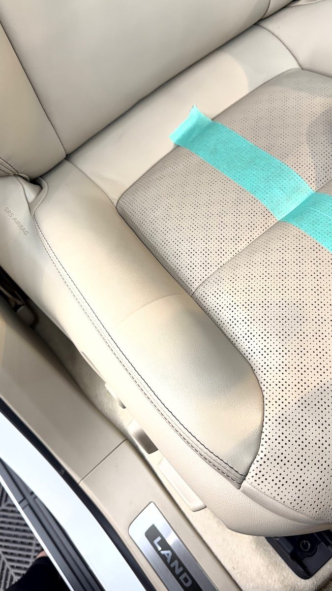 白いレザーシートの汚れ。運転席の座面の横、乗り降りで擦れる部分に黒ずみが見える