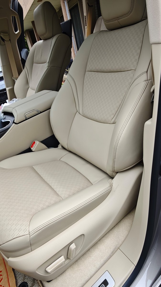 ランドクルーザーの運転席。明るいベージュの本革シートと、座面・背もたれのパンチング（小さな穴の模様）